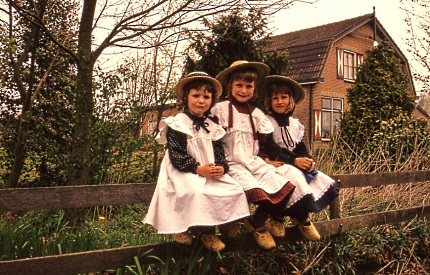 Drie kleine kleuters op een hek 