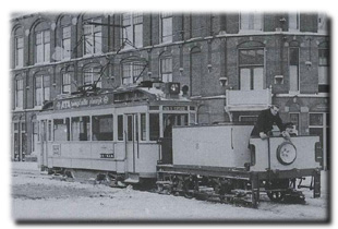 winter-1956-009_grDe tram blijft vastzitten in de sneeuw, aan het Stationsplein in Den Haag op 13 februari 1956. Foto: ©Frits van Dam