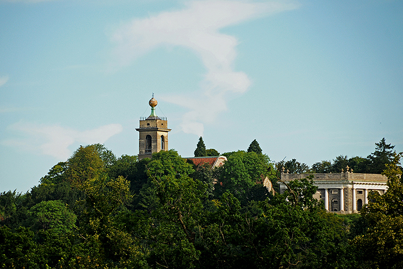 De oude St.Lawrence Church met goudkleurige bol is op grote afstand in de omgeving zichtbaar. Het familie Dashwood mausoleum is net -rechts- zichtbaar.