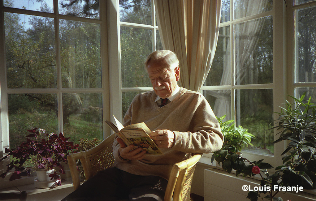 Wil Huygen thuis in Tienhoven (1995) lezend in zijn boek "En buiten lag het paradijs" - Foto: ©Louis Fraanje