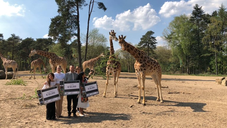 Doutzen Kroes met de drie prijswinnaars tussen de giraffen in Burgers' Zoo - Foto: ©Omroep Gelderland