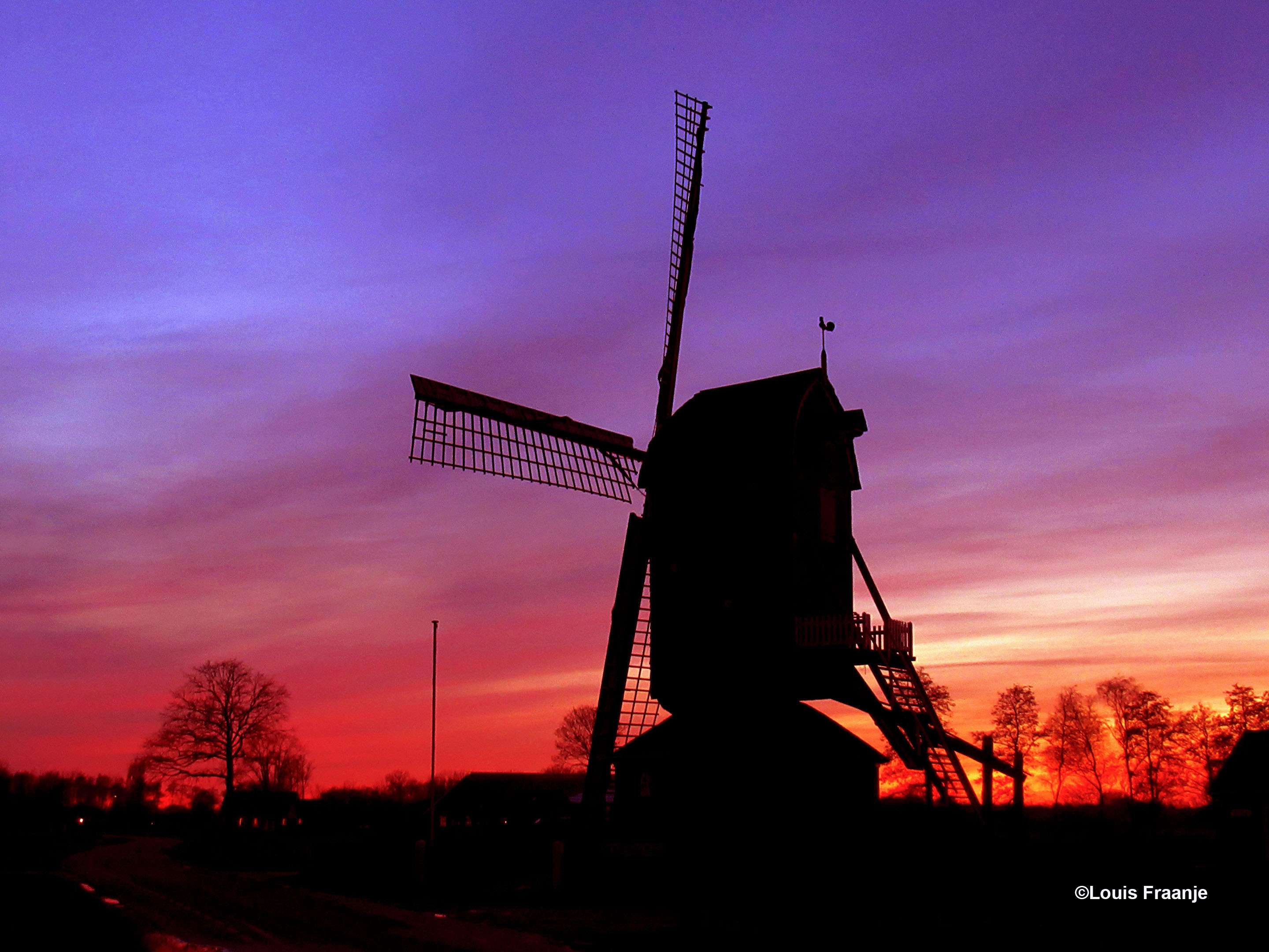 Avondrood met het silhouet van 'Den Olden Florus' of 'Kallenbroeker Molen' op de voorgrond - Foto: ©Louis Fraanje