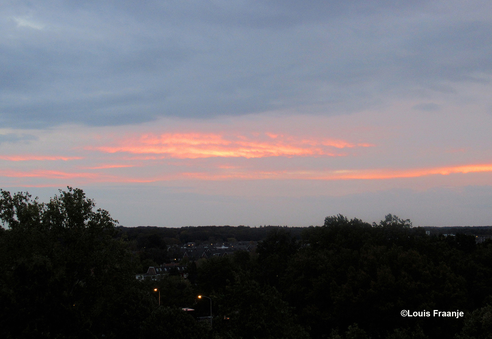Tussen het grijs/blauwe wolkendek kwam heel even maar, een kleurrijk morgenrood tevoorschijn - ©Louis Fraanje