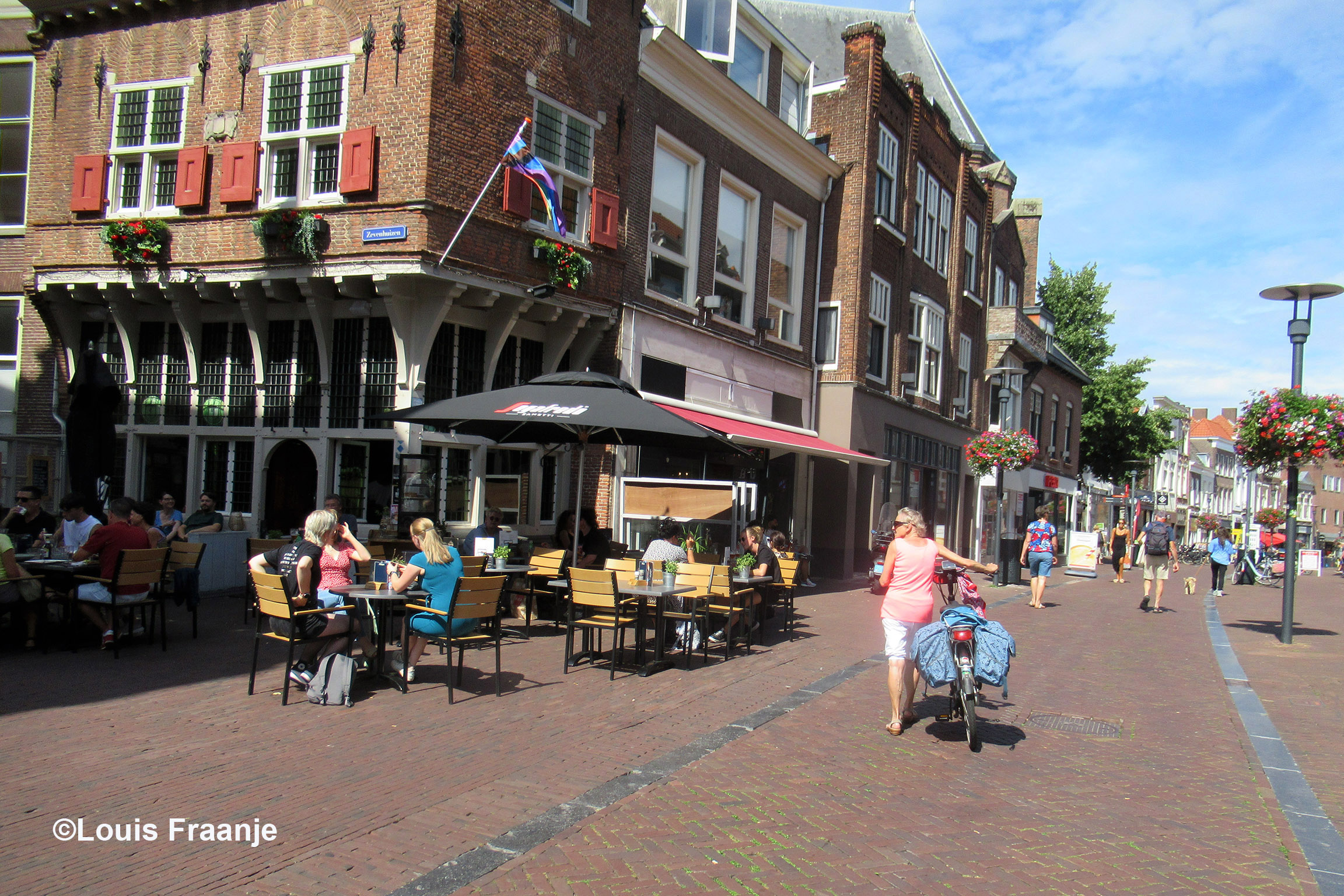 Met de fiets aan de hand door de Langestraat, links het Stadscafé "In den Grooten Slock" - Foto: ©Louis Fraanje