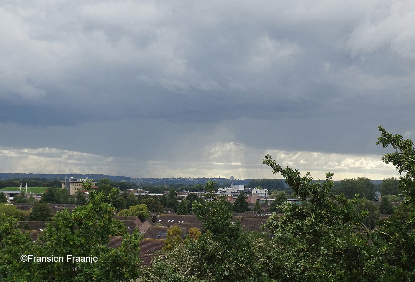 Vanaf ons balkon een prachtig vergezicht richting Rhenen, maar er hangen wel donkere wolken, waaruit een fikse regenbui valt - Foto: ©Fransien Fraanje