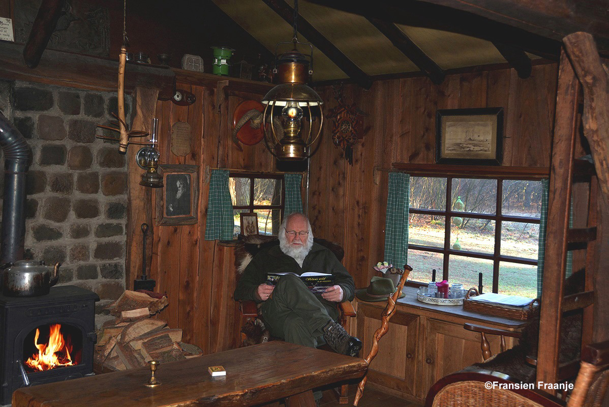 De schrijver Louis Fraanje met zijn fotoboekje in de oude jachthut – Foto: ©Fransien Fraanje